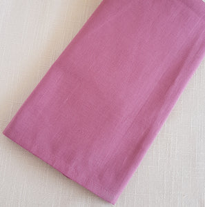 Raspberry  pink napkin on a textured beige background.
