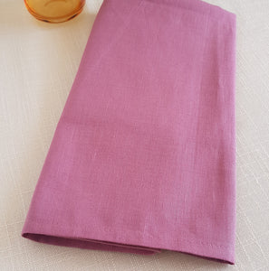 Folded raspberry pink colour textured fabric napkin.