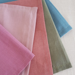 linen–cotton dinner napkin with 2cm hem and mitered corners, neatly folded for a table setting. 5 different napkins in colours salmon, light pink, raspberry pink, khaki green and marine blue.