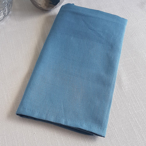 Dusty marine blue linen–cotton dinner napkin with 2cm hem and mitered corners, neatly folded for a table setting