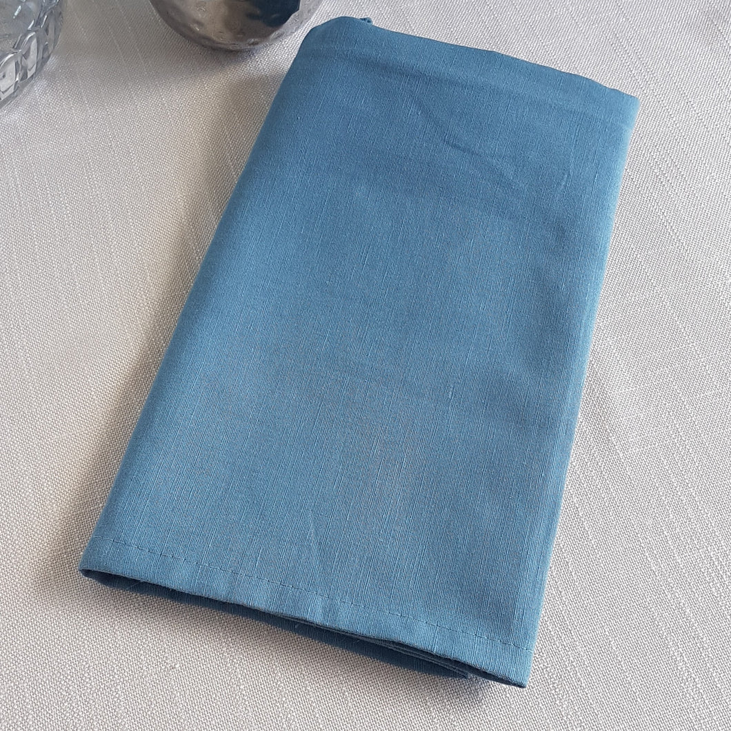 Dusty marine blue linen–cotton dinner napkin with 2cm hem and mitered corners, neatly folded for a table setting