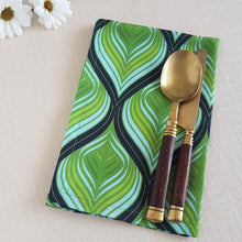 Load image into Gallery viewer, Green, aqua, and black swirl design on a linen–cotton cocktail napkin with crisp, tailored edges