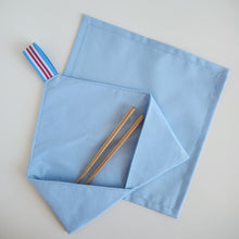 Load image into Gallery viewer, Light blue fabric cutlery holder pouch with wooden chopsticks and a striped elastic loop next t on a light gray background a cocktail size light blue cotton napkin serviette

