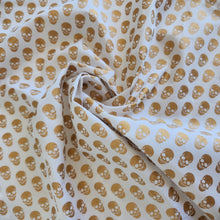 Load image into Gallery viewer, Fabric with gold skull pattern on a white background