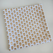 Load image into Gallery viewer, Fabric with gold skull pattern on a white background
