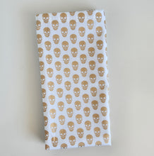 Load image into Gallery viewer, Folded fabric with gold skull pattern on a white background
