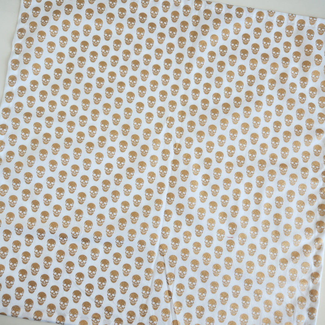 Fabric with a pattern of small skulls on a white background