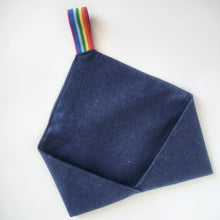 Load image into Gallery viewer, Dark blue linen cutlery wrap shaped like an open envelope with a rainbow striped elastic loop at top, on a white background
