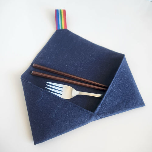 Dark midnight blue linen cutlery wrap  utensil holder with fork and chopsticks , with a rainbow elastic loop, on a white background
