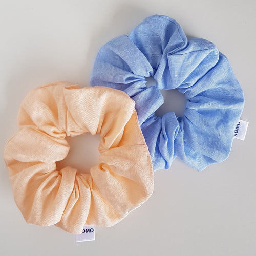 A gorgeous selection of two linen scrunchies. 100% Linen Hair Scrunchies. Twin Pack. Two Linen Scrunchies with one in Pastel Peach colour and one in Sky Blue.