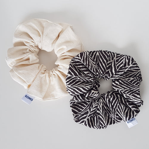 Two Pack Linen Scrunchie. One Soft Cream Coloured Scrunchie and One Beautiful Black and Cream Leaf Print Scrunchie. Enjoy wearing this gorgeous pair of hair scrunchies from our linen collection. Perfect gift packs for the scrunchie lover in your life. Linen hair scrunchies. 