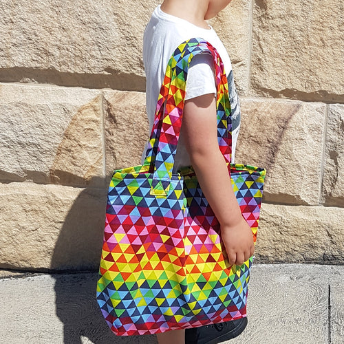 Triangle scales uroko print. Bright coloured rainbow bag in pink, red, blue, yellow, green, orange, purple, Library bag thats perfect for little fingers to open and close. Fully lined with interior pocket and magnetic snap to close. 